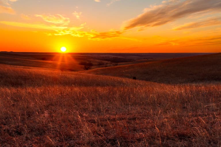 Sonnenuntergang über Hügeln - Symbolbild für Woher bekommt Whisky seine Farbe?