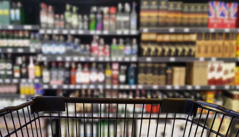 Ein Einkaufswagen fährt durch die Getränkeabteilung eines Supermarkts als Titelbild zur Folge 5 – Geschmacklich auf Abwegen