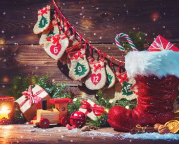 Christmas background. Advent calendar and Santa's shoe with gifts on rustic wooden background