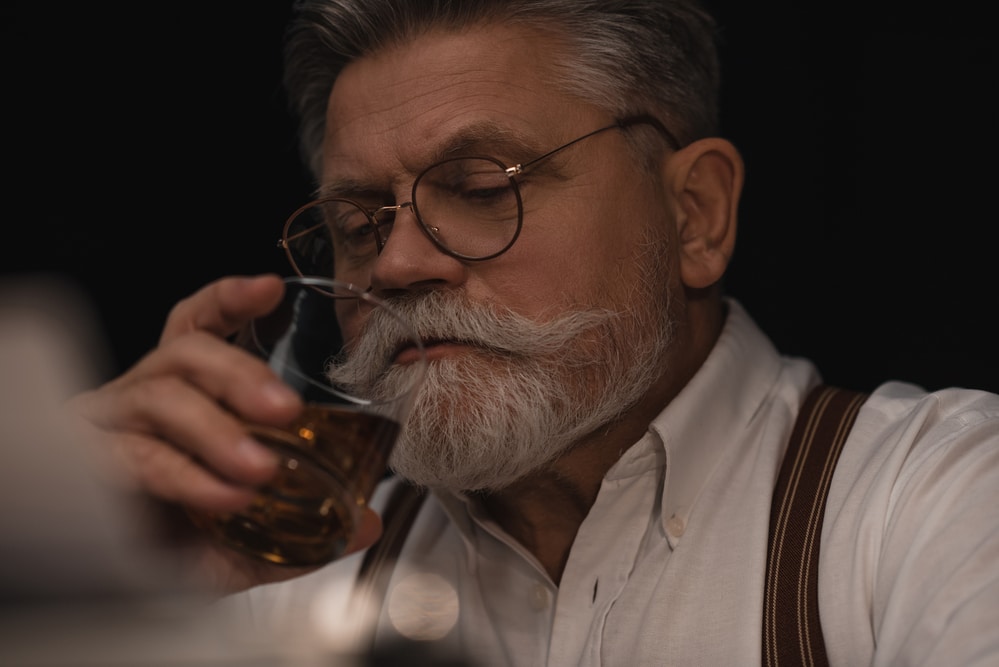 Ein Mann Trinkt Whisky aus einem Nosing Glas als Symbolbild für: Welche Whisky Gläser gibt es?