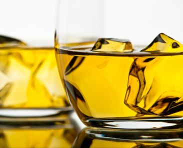Two glasses of whiskey on white background