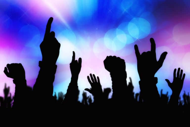 Silhouetten der Hände des Konzertpublikums, die die Band auf der Bühne unterstützen. Das Titelbild zur Folge 35 – Teerenpeli, Whisky & Heavy Metal
