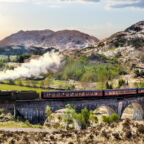Glenfinnan Railway Viaduct in Scotland with the Jacobite steam train against sunset over lake