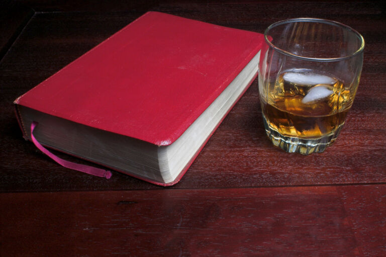 Ein Glas Bourbon auf Eis neben einer Bibel als Titelbild zur Folge 97 – Gottes Werk und Bourbons Beitrag