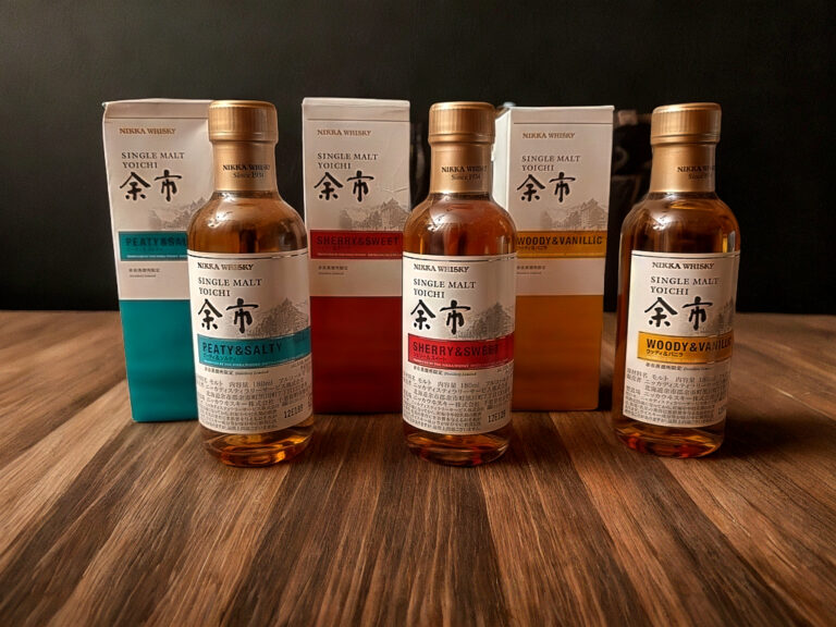 Titelbild Grab The Glass Folge 195: drei Nikka Yoichi Single Malt Miniaturen - Peaty & Salty, Sherry & Sweet und Woody & Vanillic – mit passenden Boxen auf einem Holztisch vor dunklem Hintergrund.