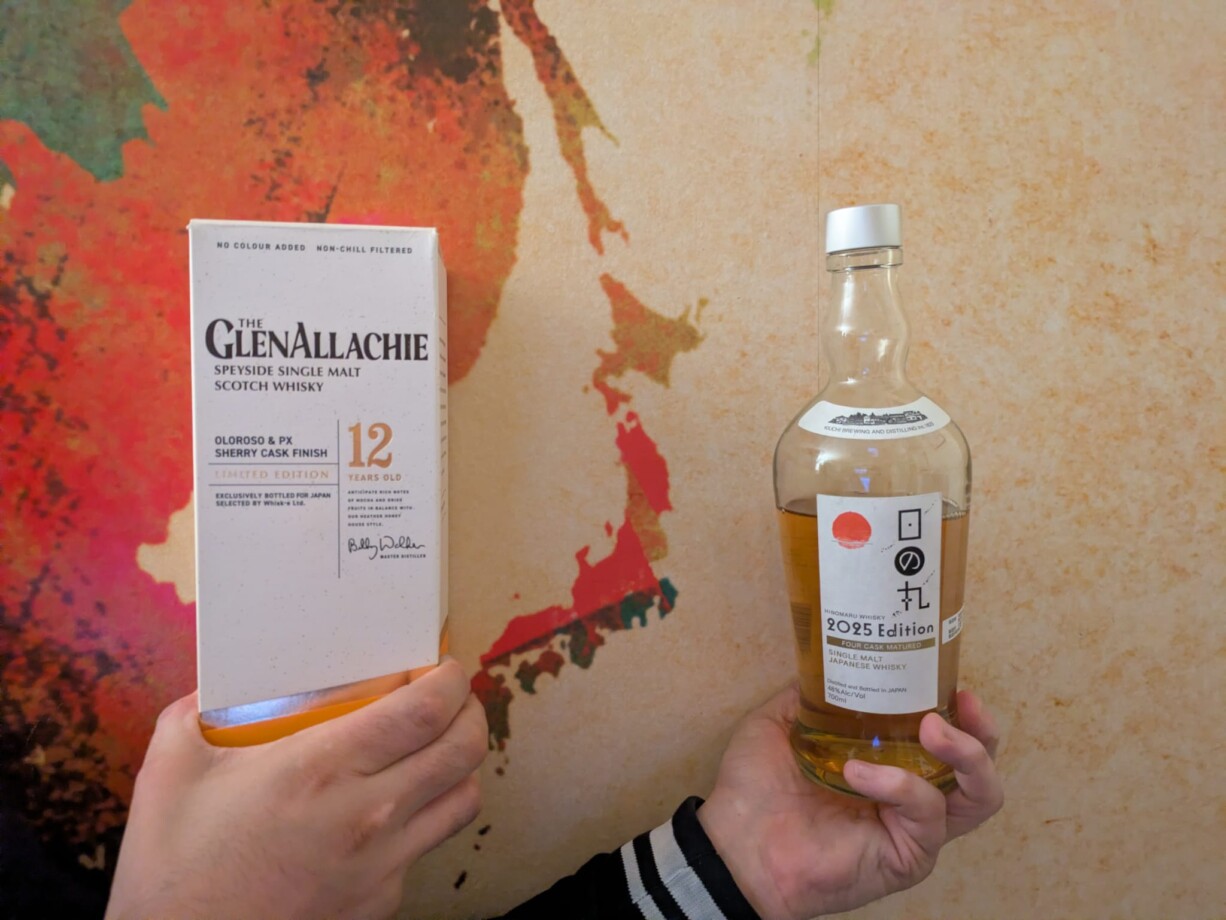 Zwei Hände halten die Whisky-Mitbringsel der Folge vor einer illustrierten Japan-Karte: Links die weiße Verpackung des schottischen GlenAllachie 12 Jahre (Oloroso & PX Sherry Cask Finish, Limited Edition für Japan) und rechts die Flasche des japanischen Hinomaru Whisky 2025 Edition (Four Cask Matured).