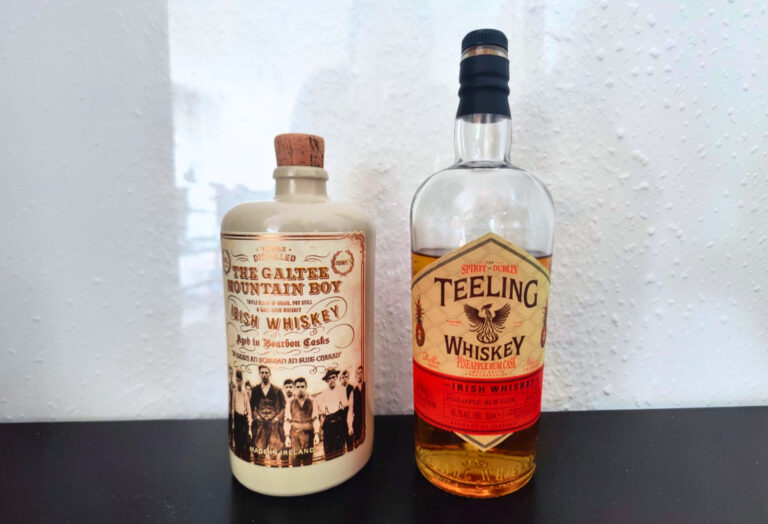 The Galtee Mountain Boy und Teeling Pineapple Rum Cask stehen nebeneinander auf einem schwarzen Tisch.