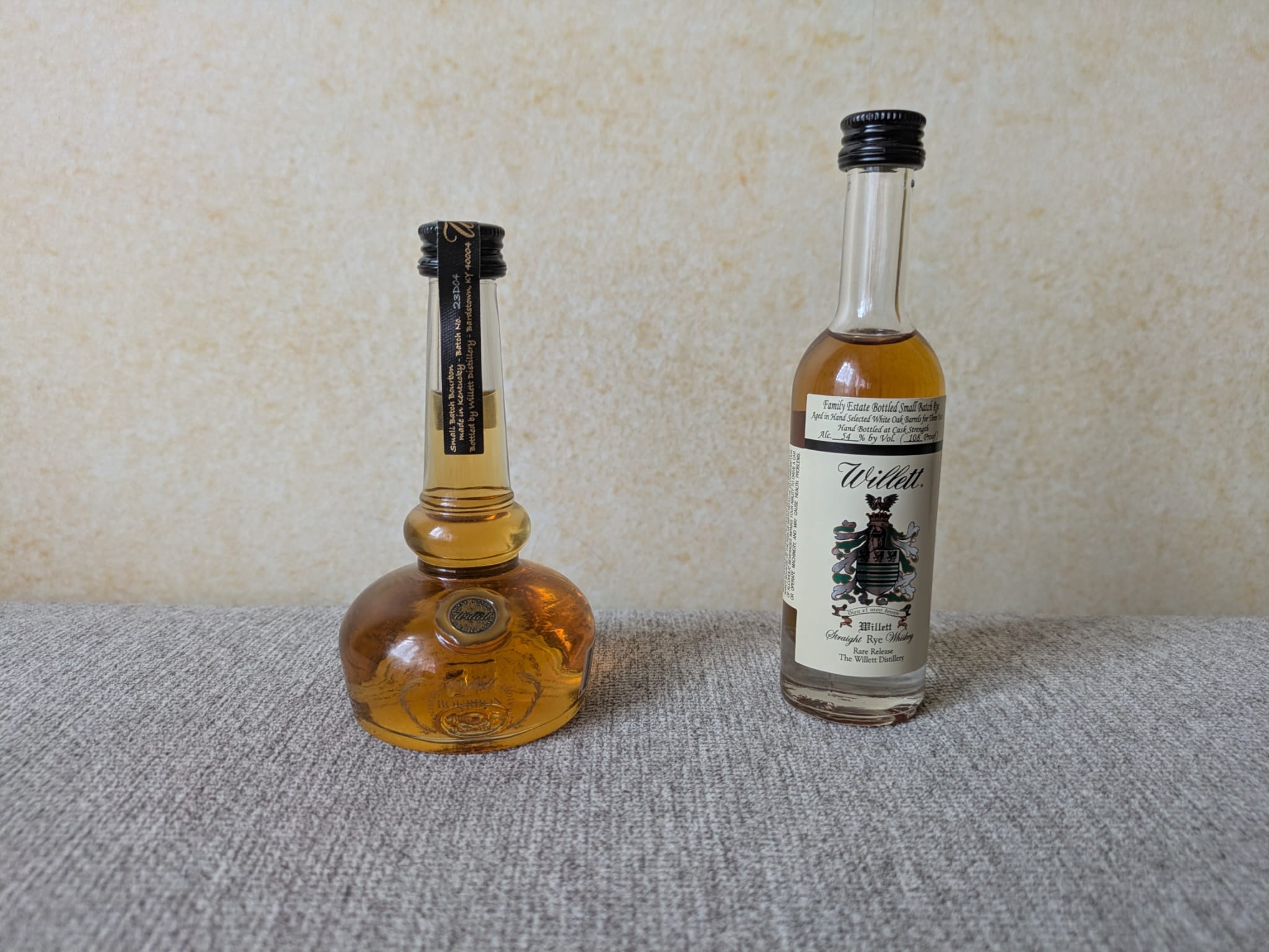 Willett Pot Still Reserve Bourbon und Willett Family Estate Small Batch Rye stehen nebeneinander auf einem grauen Untergrund.