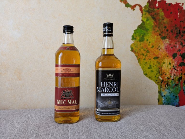 Mic Mac Finest Blended Whisky und Henri Marcoux Canadian Whisky stehen nebeneinander auf einem grauen Untergrund.